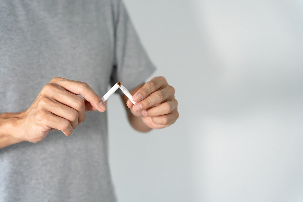 Rauchen aufhören - Mann zerbricht Zigarette 